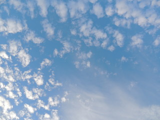 Cumulus and cirrus clouds with sun on left