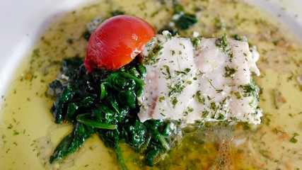 healthy eating - grilled fish, cherry tomatoes, spinach and olive oil