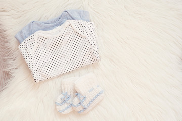 Baby Bodysuit Mockup. Styled Stock Photography. Clothes For A Boy. Jumpsuits, Rompers On A White Fur Carpet. Newborn Baby Concept. Baby Boy Clothes Set