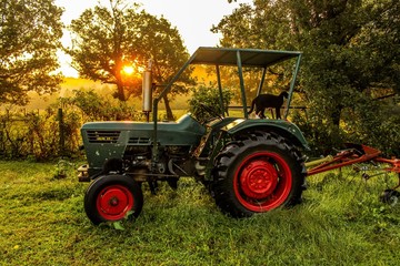 Selective Soft Focus of an Antique Obsolete Tractor in a field at sunrise