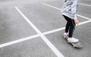 Teenager skateboarder boy with a skateboard on asphalt playground doing tricks. Youth generation Freetime spending concept image. © Soloviova Liudmyla