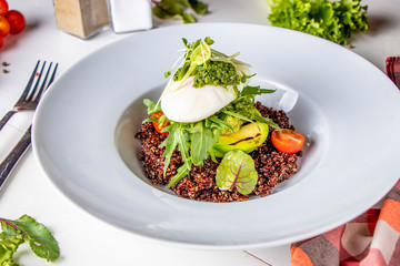 Quinoa with avocado, poached egg and microgreen in a white plate, horizontal orientation, close-up