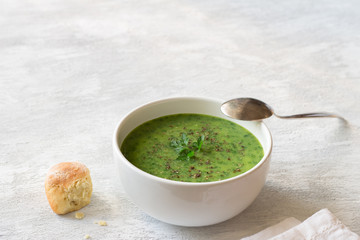 Healthy green kale cream soup with potatoes and bread on gray background with free space. simple homemade food