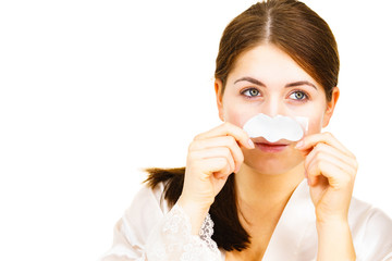 Woman applying pore strips on nose