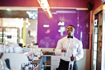 African american bartender at bar flair in action, working behind the cocktail bar. Alcoholic beverage preparation.