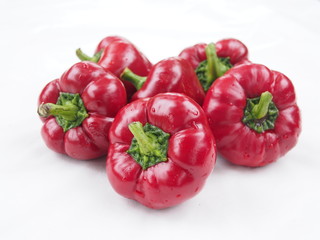 A bunch of ripe red sweet peppers on a white background