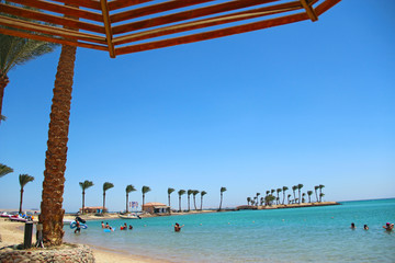 tropical resort with palm trees sand and sandy beach. Paradise rest on seashore of Red sea