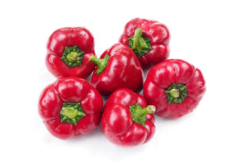 A bunch of ripe red sweet peppers on a white background