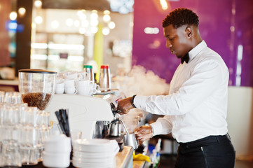 African american bartender barista at bar preparing coffee.