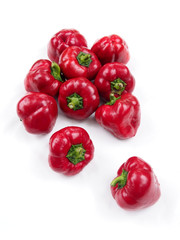 A bunch of ripe red sweet peppers on a white background