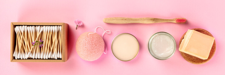 Plastic-free, zero waste cosmetics, flat lay on a pink background. Bamboo toothbrush, cotton swabs, konjac sponge, natural organic products, panoramic photo