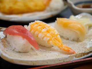 Closeup macro detail of a Sushi platter of Maguro bluefin tuna, Ebi shrimp, and salmon. Narita, Chiba, Japan. Travel and traditional Sashimi cuisine.