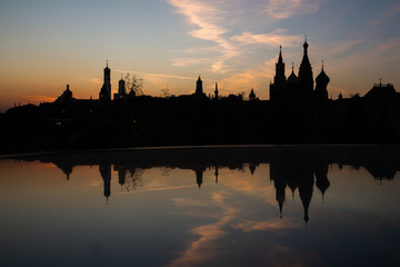 Kremlin silhouette view at sunset in Moscow, Russia. Dormition orthodox cathedral in the middle with other bell towers and towers on the sides. Architecture and travel concepts