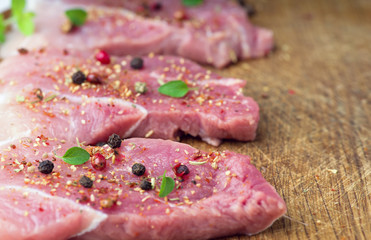 Steaks sprinkled with spices and herbs. Juicy steaks for a barbecue close up.