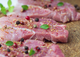 Steaks sprinkled with spices and herbs. Juicy steaks for a barbecue close up.