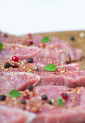 Steaks sprinkled with spices and herbs. Juicy steaks for a barbecue close up.