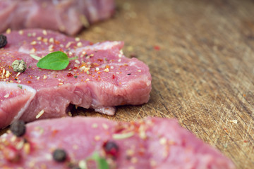 Steaks sprinkled with spices and herbs. Juicy steaks for a barbecue close up.