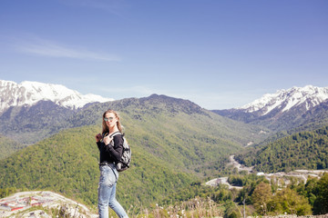 Naklejka premium Portrait of a beautiful young girl lover and protector of the environment and trekking goes to picturesque places in the mountains. Concept of Unity with nature, ecotourism