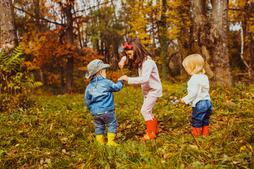 Fototapeta premium Little children playing in the park in autumn