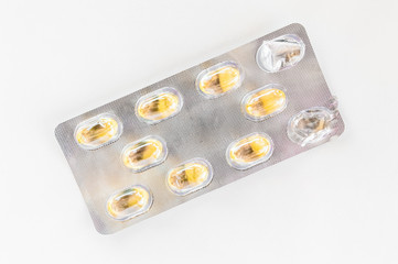Yellow capsules packed in a blister pack isolated on white background