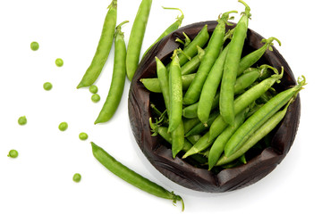 Fresh green peas in a bowl on white background