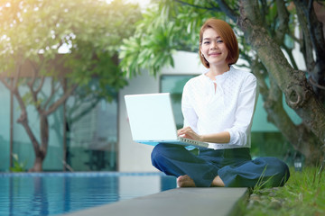 Asian Woman sitting to use laptop at park outdoor