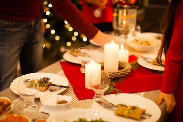 Friends celebrating Christmas or New Year eve. Party table with champagne.