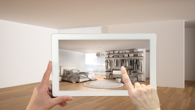 Augmented reality concept. Hand holding tablet with AR application used to simulate furniture and design products in empty interior with parquet, luxury bedroom with walk-in closet