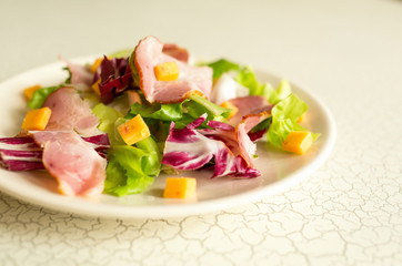 A plate of salad of green leaves, ham and cheese. Plate of salad with green leaves, ham and cheese. Intercontinental breakfast at the hotel.