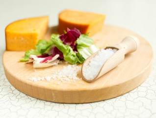 Fresh lettuce, cheese, ham and sea salt on a cutting board. Intercontinental breakfast at the hotel.