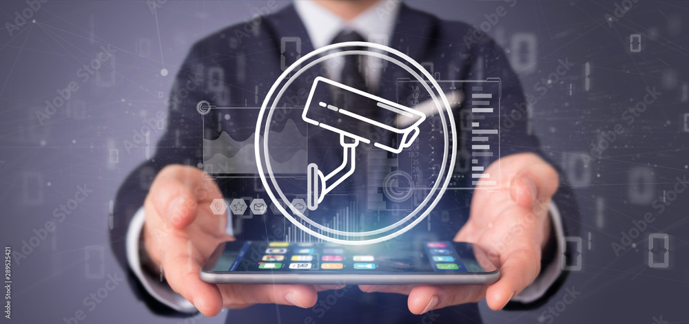 Poster businessman holding security camera system icon and statistics data - 3d rendering