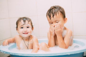 children, brother and sister in the bathroom swimming, playing splashing