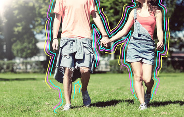 Obraz premium holidays, vacation, love and people concept - happy teenage couple walking in summer park with glowing lines