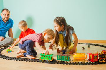 Little children play with a toy railway