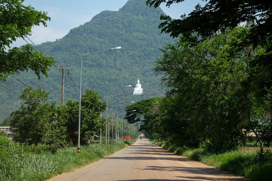 View of Wat Thep Phithak In Korat province, Thailand, saw a large white Buddha statue. On the mountains and green trees.