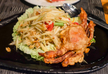 Recommend Thai food, consists of fried sticky rice, fried chicken, papaya salad and fresh vegetables.