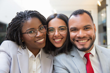 Multiethnic business colleagues smiling at camera. Portrait of happy young business people smiling at camera together. Cooperation concept