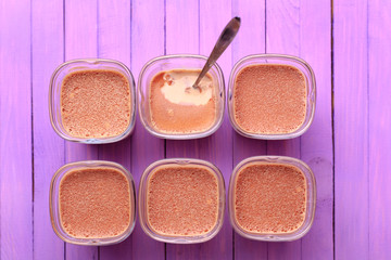 Top view - Six portions of chocolate milk dessert are on a wooden table of purple.