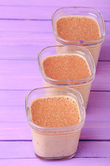 Chocolate Yogurt. Portions of chocolate milk dessert are on a wooden table of purple.
