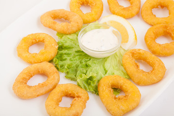 Deep fried calamari rings (squid rings), with sauce in plate