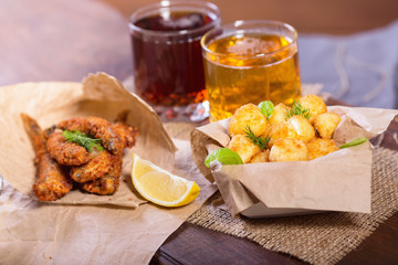 Beer snacks. Fried fried fish and cheese balls with lemon and greens. Snacks to different beers.