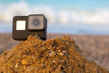 An action camera takes a sunset by the sea. A video camera mounted for shooting on a pile of sea...
