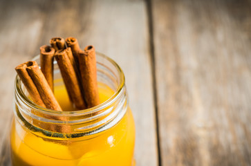 Fresh peach juice with cinnamon spices in jar. Selective focus. Shallow depth of field.