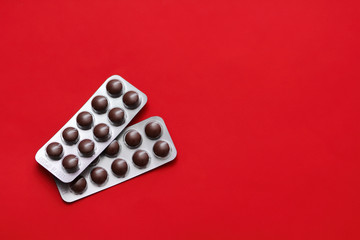 Set of pills blisters isolated on solid red background. Medical concept.  Potent drugs. Brown pills.