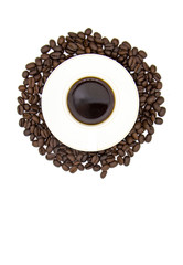white Cup of coffee on a white plate surrounded by roasted coffee beans