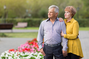Man and woman pensioners gently each other in a city park