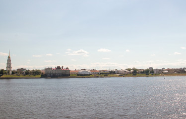 Fototapeta na wymiar Rybinsk. View of the building of the grain exchange, the Holy Transfiguration Cathedral and the bridge over the Volga river. View from the river