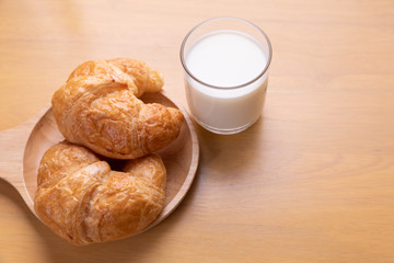 freshly baked croissants and milk cup on table.