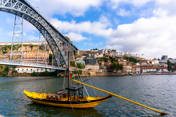 old Porto and traditional boats with wine barrels near famous Dom Luiz bridge,Portugal