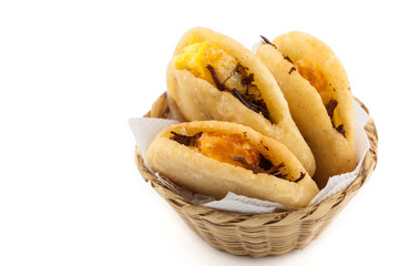 Arepa de huevo. Traditional Colombian fried arepa filled with egg and shredded meat on white background